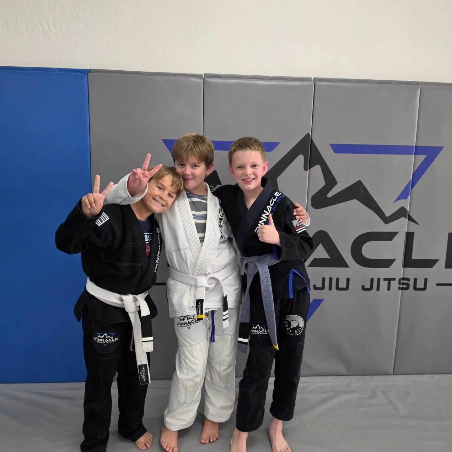 Three young students in their gis after a kids Brazilian Jiu Jitsu class at Pinnacle